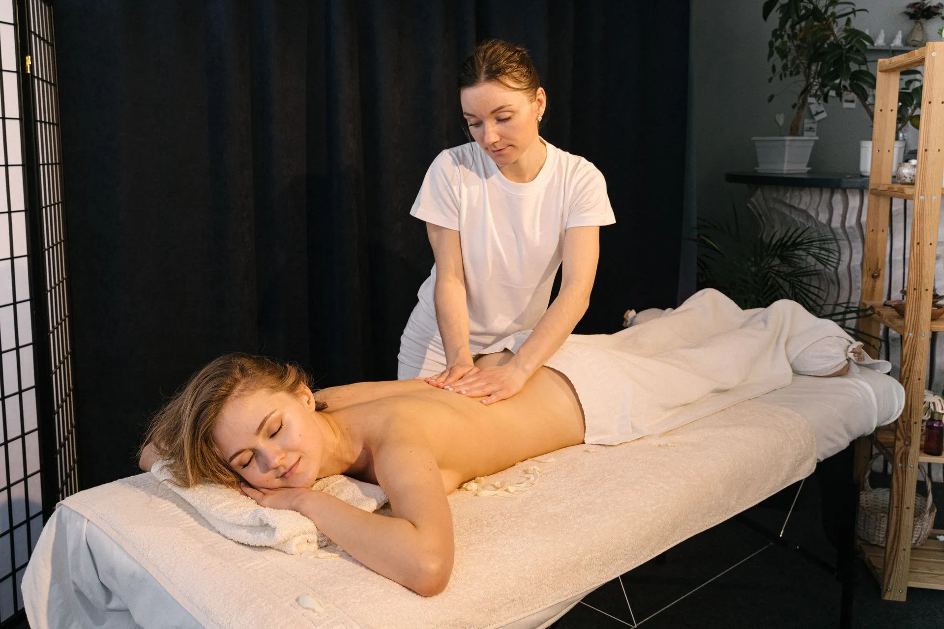 Massage therapist giving a relaxing back massage in a calm treatment room